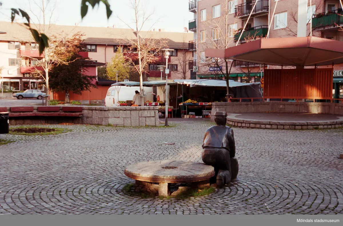 Skulpturen Albert, en scen och torghandel. Mölndalsbro i dag - ett skolpedagogiskt dokumentationsprojekt på Mölndals museum under oktober 1996. 1996_1098-1115 är gjorda av högstadieelever från Kvarnbyskolan 9C, grupp 5. Se även 1996_0913-0940, gruppbilder på klasserna 1996_1382-1405 samt bilder från den färdiga utställningen 1996_1358-1381.