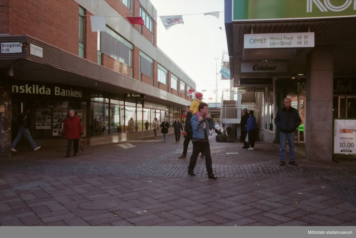 Nygatan söderut. Mölndalsbro i dag - ett skolpedagogiskt dokumentationsprojekt på Mölndals museum under oktober 1996. 1996_1116-1134 är gjorda av högstadieelever från Kvarnbyskolan 9C, grupp 6. Se även 1996_0913-0940, gruppbilder på klasserna 1996_1382-1405 samt bilder från den färdiga utställningen 1996_1358-1381.