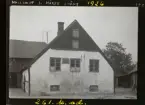 Hallkvist 1. Hörby, Skåne 1926. 
Gaveln av en byggnad med butik, skyltar i fönstren och på fasaden.