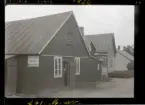 Svedala, Skåne 1926.
Man i dörröppning till byggnad med skylt: J.L. Ahl. Läder- & Råläderaffär.