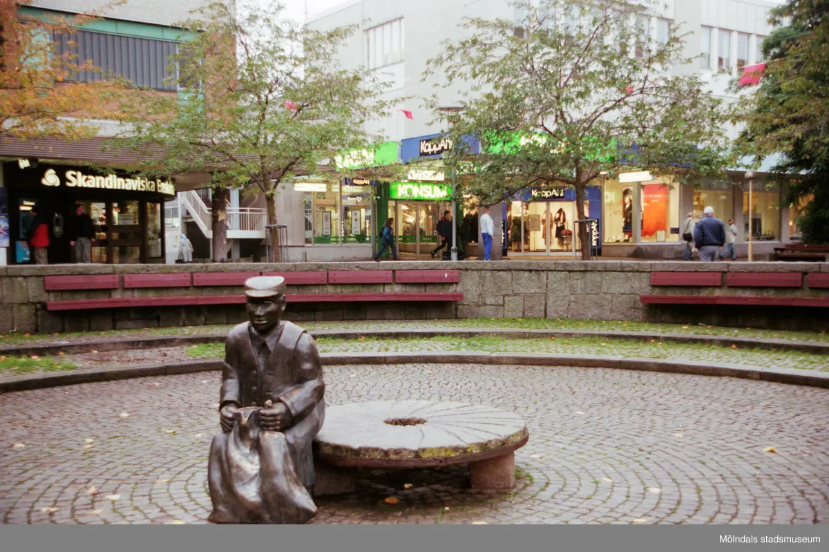 Alberts torg/Mölndals torg år 1996. Mölndalsbro i dag - ett skolpedagogiskt dokumentationsprojekt på Mölndals museum under oktober 1996. 1996_1135-1152 är gjorda av högstadieelever från Kvarnbyskolan 9D, grupp 1. Se även 1996_0913-0940, gruppbilder på klasserna 1996_1382-1405 samt bilder från den färdiga utställningen 1996_1358-1381.