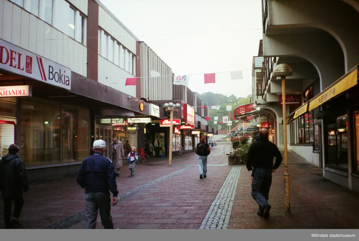 Brogatan västerut. Mölndalsbro i dag - ett skolpedagogiskt dokumentationsprojekt på Mölndals museum under oktober 1996. 1996_1212-1226 är gjorda av högstadieelever från Kvarnbyskolan 9D, grupp 5. Se även 1996_0913-0940.