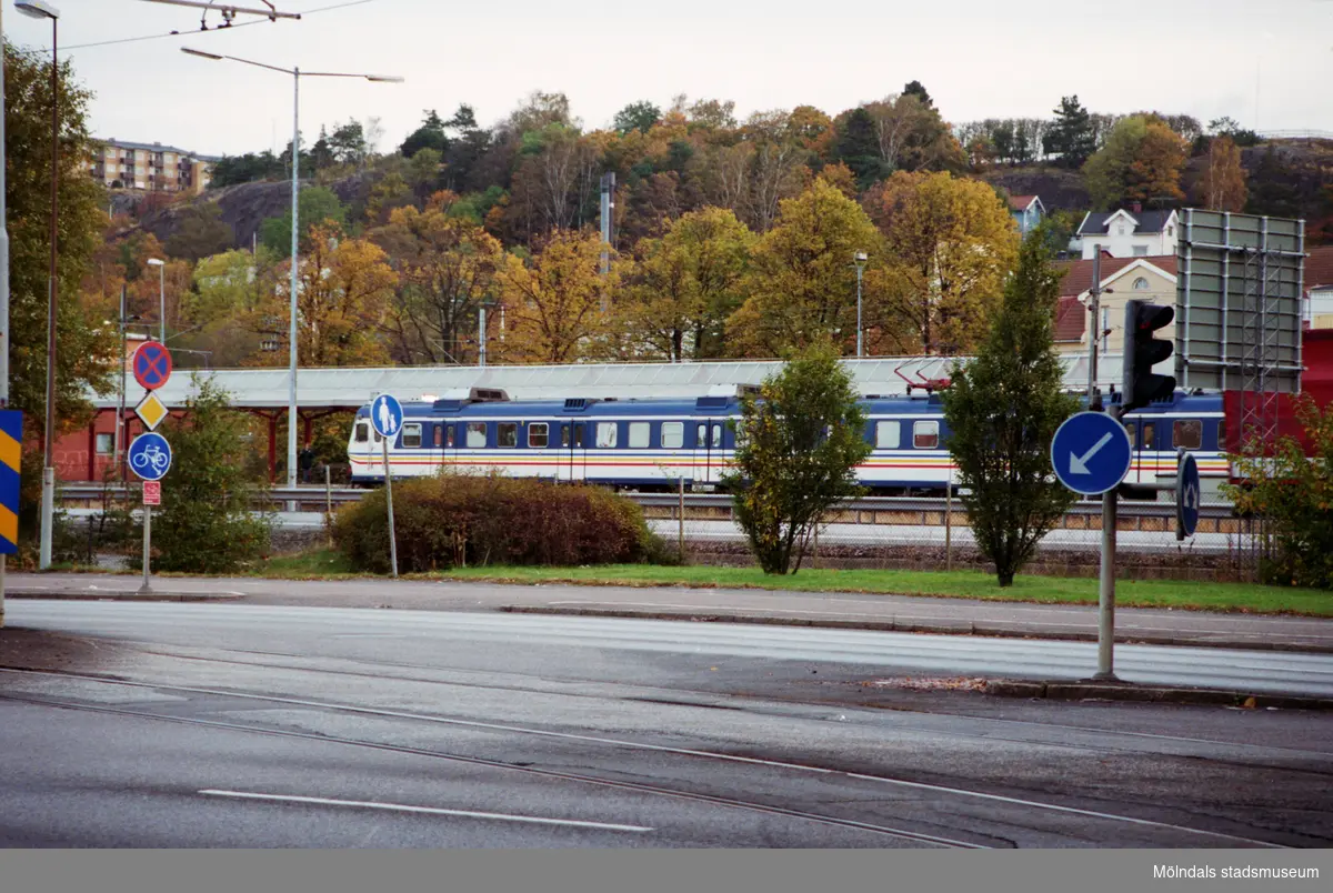 Vy österut över Göteborgsvägen på pendeln mot Göteborg. Mölndalsbro i dag - ett skolpedagogiskt dokumentationsprojekt på Mölndals museum under oktober 1996. 1996_1264-1282 är gjorda av högstadieelever från Åbyskolan 8A, grupp 2. Se även 1996_0913-0940, gruppbilder på klasserna 1996_1382-1405 och bilder från den färdiga utställningen 1996_1358-1381.