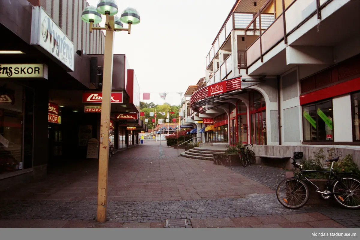 Brogatan västerut. I fonden skymtas Sahlins terrass. Mölndalsbro i dag - ett skolpedagogiskt dokumentationsprojekt på Mölndals museum under oktober 1996. 1996_1264-1282 är gjorda av högstadieelever från Åbyskolan 8A, grupp 2. Se även 1996_0913-0940, gruppbilder på klasserna 1996_1382-1405 och bilder från den färdiga utställningen 1996_1358-1381.