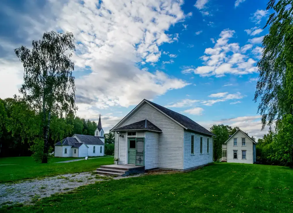 foto av friluftsmuseet på Norsk Utvandrermuseum. I bilde sees skolebygningen og kirken