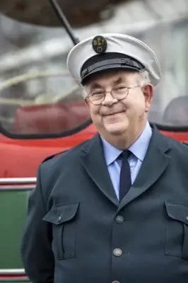 Portrett av sjåfør av en veteranbuss med tidsriktig hatt og frakk