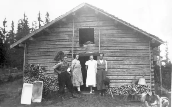 Foto i svart-hvitt. Fire unge mennesker står foran Skålbergsætra en sommerdag.