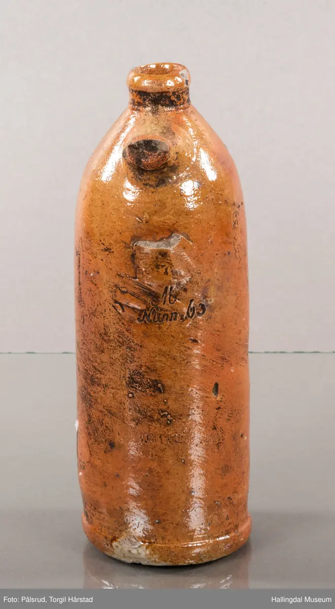 Keramikkflaske med ødelagt hank. Rustbrun, glassert.