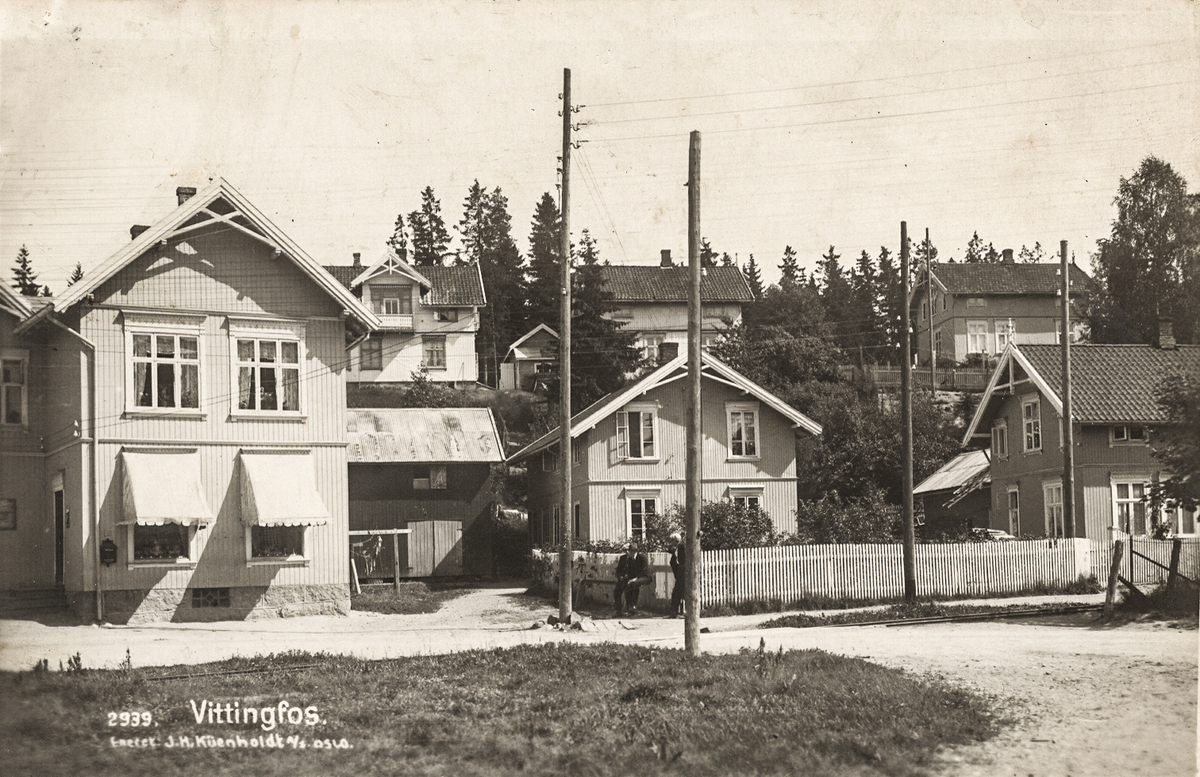 Foretningen til venstre Kooperativen, i midten sykkelfabrikken til Jørgen Rønneberg.  Der bygdes  syklene Greven og Vittingen.
Skimter jernbaneskinnene på Holmestrand-Vittingfossbanen. 
Foto: Küenholdt, Oslo