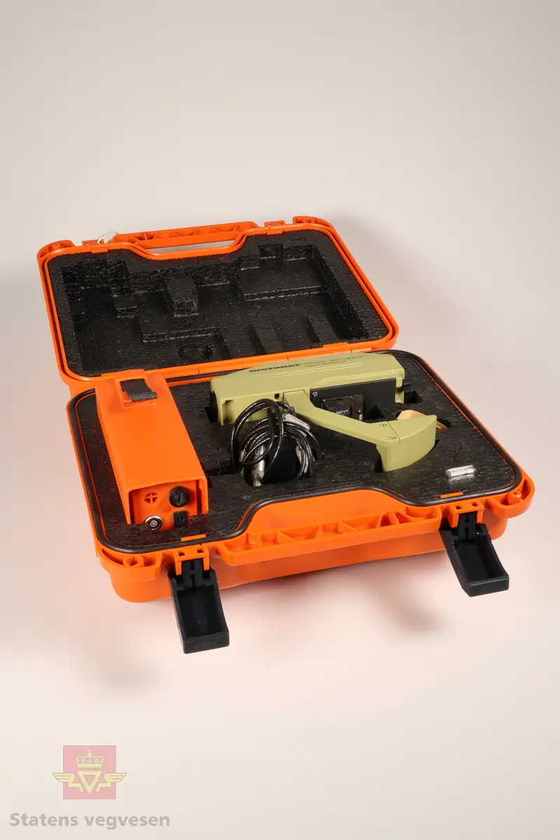 En oransje beholder som inneholder en elektronisk avstandsmåler av typen DISTOMAT WILD DI1600, et eksternt batteri, ti ekstra sikringer, en LEMO kabel og en unbrakonøkkel. 