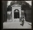 Portal till Katarina kyrkogård. Södermalm, Stockholm. En man passerar med ett paket under armen. 
61/1941 Konrad Elméus Nm 102