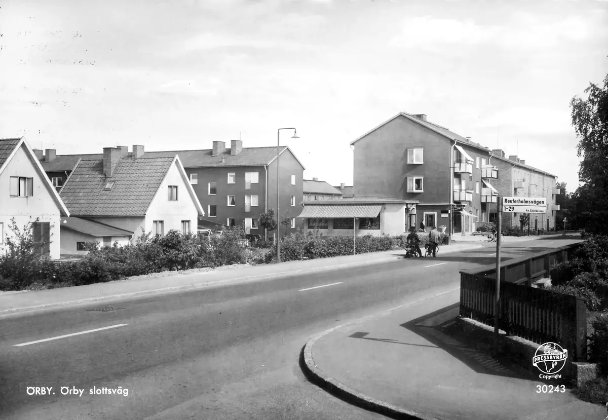ÖRBY. Örby slottsväg ; BHF studiecirkel vt 2016:
Bilden tagen från korsningen med Reuterholmsvägen. Vägen in till vänster vid konsumbutiken, framför cyklisterna, är Täckhammarsvägen. Bilden från slutet av 1950-talet eller möjligen början av av 1960-talet.