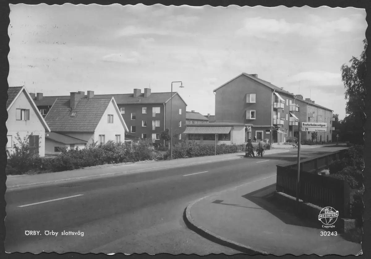 ÖRBY. Örby slottsväg ; BHF studiecirkel vt 2016:
Bilden tagen från korsningen med Reuterholmsvägen. Vägen in till vänster vid konsumbutiken, framför cyklisterna, är Täckhammarsvägen. Bilden från slutet av 1950-talet eller möjligen början av av 1960-talet.