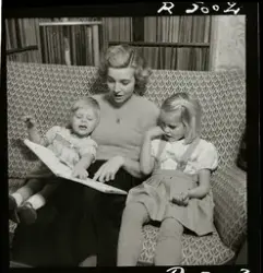 Sångerskan Alice Babs sitter i en soffa och läser en saga fö