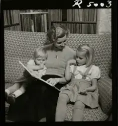 Sångerskan Alice Babs sitter i en soffa och läser en saga fö