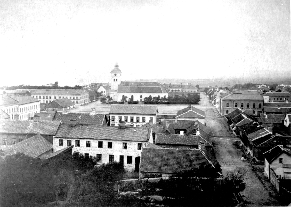 Stadsvy över Varberg tagen från kvarnen i kv Pilhagen mot norr med kvarteren kring torget och kyrkan i fonden. Till höger går Drottninggatan.