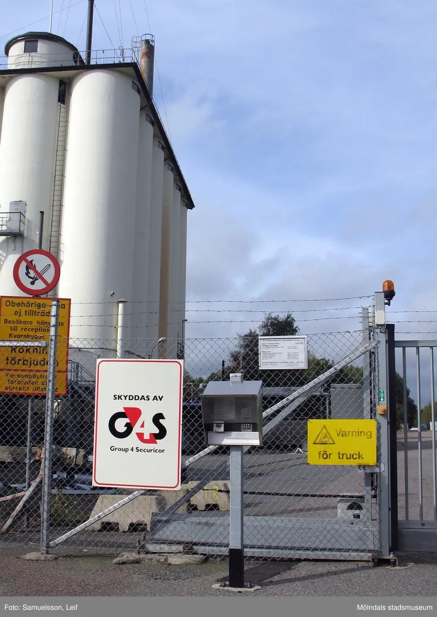 Grind och stängsel med diverse skyltar vid silobyggnaden på Soabs industrianläggning i Mölndals Kvarnby, år 2007. Anläggningen användes vid fototillfället av Hexion Speciality Chemicals Sweden AB.