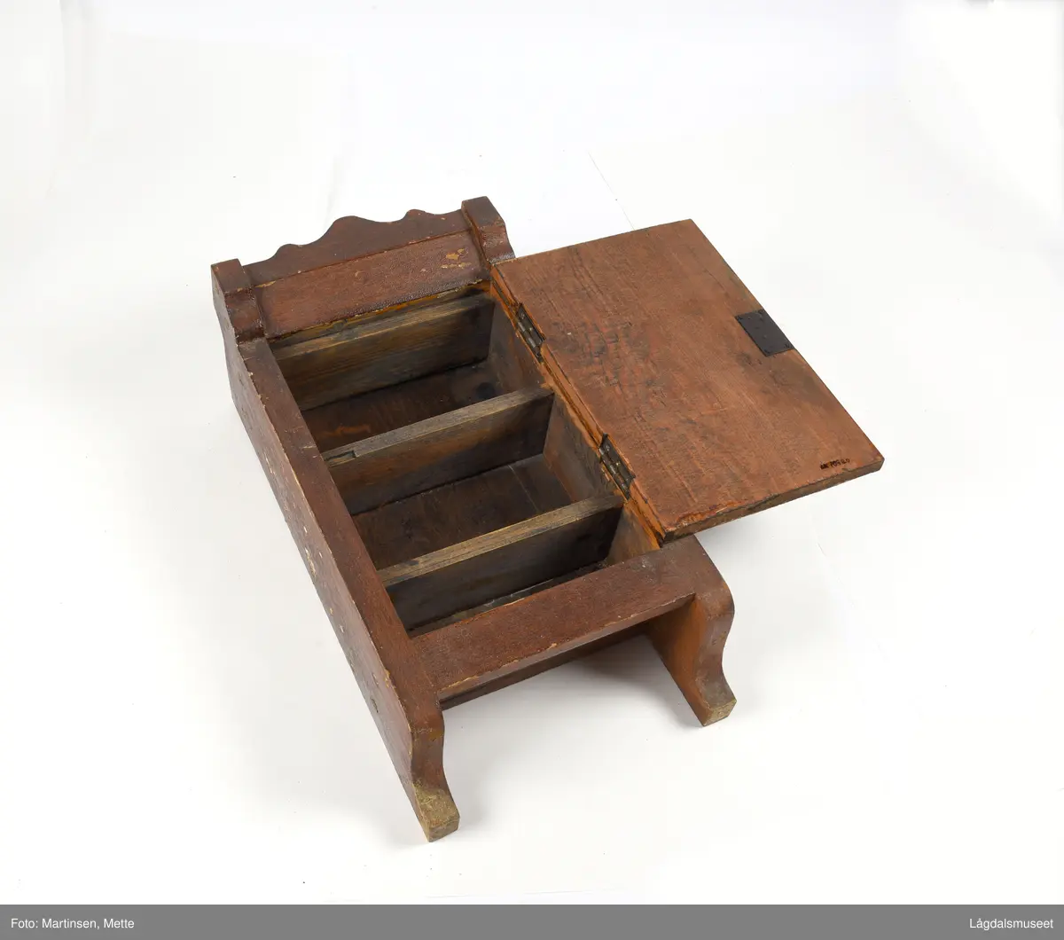 Hengeskap med hengslet dør. Dør med markert speil. Lås med nøkkel. Innvendig er det tre hyller. Beslag for oppheng.