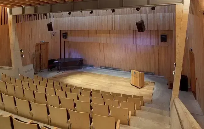 Sal med stolrader og vakkert belyst scene