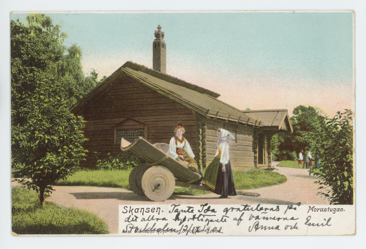 Handkolorerat vykort med motiv av Morastugan på Skansen, Stockholm. Vykortet är poststämplat den 14/9-1902.