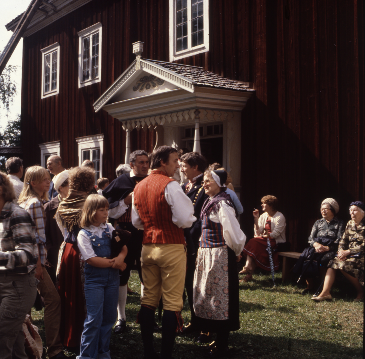 En stor folksamling utanför Edsbyns Hembygdsgård Mårtes. Några av personerna är klädda i folkdräkt. Troligtvis fotograferat i samband med Volasdagen.