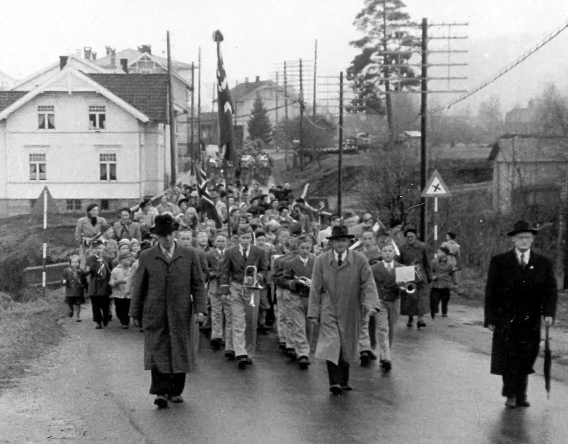 1. mai i Hvittingfoss på femtitallet.
Til høyre Hans Omholt, ordfører i Ytre Sandsvær.
Toget går på brua over Grøtterudbekken.
(ved der Hvittingfoss torg er pr. 2024)