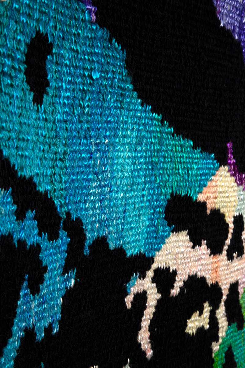 Rektangulær billedvev i gobelengteknikk, lingarn i renningen og ull og syntetgarn i innslaget. Abstrakt motiv i sterke, lysende farger. Åtte brede strenger i ulike farger på lys bunn (hver farge er satt sammen av sjatteringer i fargens tone) er flettet diagonalt i hverandre. Over dette et mønster i svart, som er inspirert av gamle stofftrykkblokker. Renningstrådene er flettet til et horisontalt bånd i øvre og nedre kant.