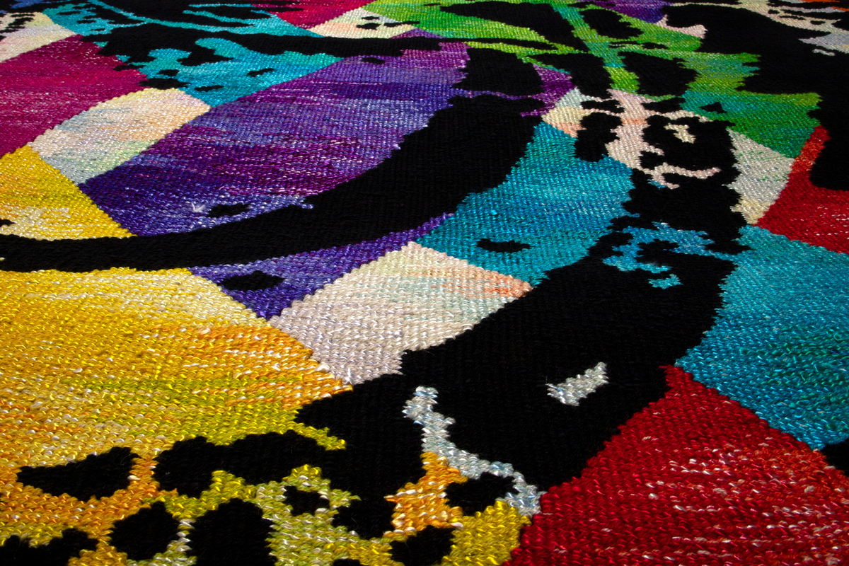 Rektangulær billedvev i gobelengteknikk, lingarn i renningen og ull og syntetgarn i innslaget. Abstrakt motiv i sterke, lysende farger. Åtte brede strenger i ulike farger på lys bunn (hver farge er satt sammen av sjatteringer i fargens tone) er flettet diagonalt i hverandre. Over dette et mønster i svart, som er inspirert av gamle stofftrykkblokker. Renningstrådene er flettet til et horisontalt bånd i øvre og nedre kant.