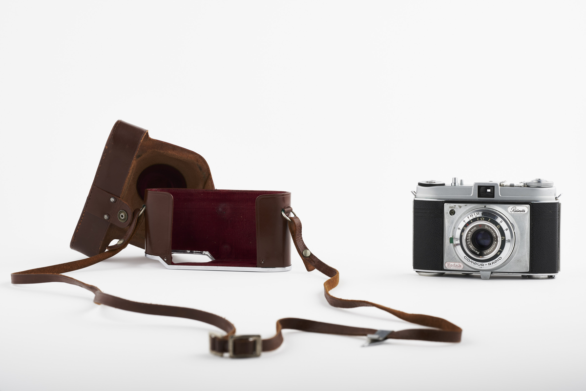 Kamera med tilhørende futteral/veske i brunt lær. Kameraet er av modellen Kodak Retinette, produsert på 1950-tallet. Det har en Schneider - Kreuznach Reomar 45mm f/3.5 linse. 

Samlingen består av diverse fotoutstyr og andre gjenstander som har tilhørt Synnøve Brændshøi sitt fotoatelier. De fleste er nok fra 1940- og 50-tallet.