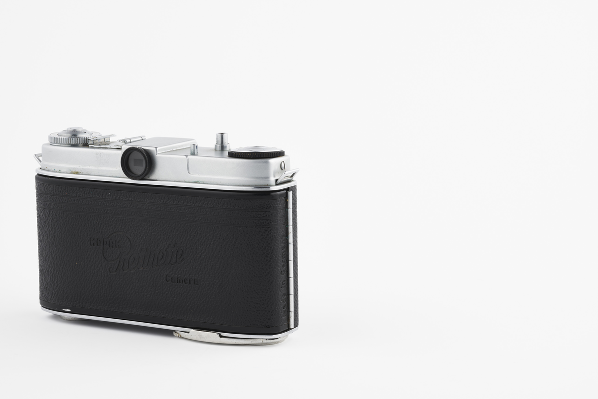 Kamera med tilhørende futteral/veske i brunt lær. Kameraet er av modellen Kodak Retinette, produsert på 1950-tallet. Det har en Schneider - Kreuznach Reomar 45mm f/3.5 linse. 

Samlingen består av diverse fotoutstyr og andre gjenstander som har tilhørt Synnøve Brændshøi sitt fotoatelier. De fleste er nok fra 1940- og 50-tallet.