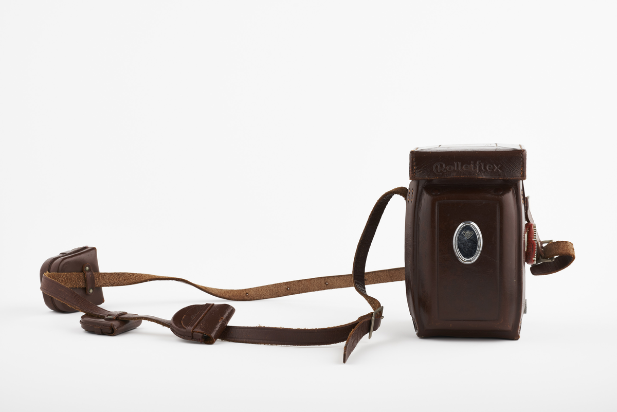 Kamera med tilhørende futteral/veske i brunt lær med fløyel på innsiden. Kameraet er et twin lens av merke Rolleiflex, trolig av modellen 2.8, produsert fra 1949 til 1956. Det har en Heidosmat 1:2,8/75 linse. Kameraetuiet har små vesker med diverse tilbehør. Har tilhørende bruksanvisning på tysk, med manglende forside.

Samlingen består av diverse fotoutstyr og andre gjenstander som har tilhørt Synnøve Brændshøi sitt fotoatelier. De fleste er nok fra 1940- og 50-tallet.