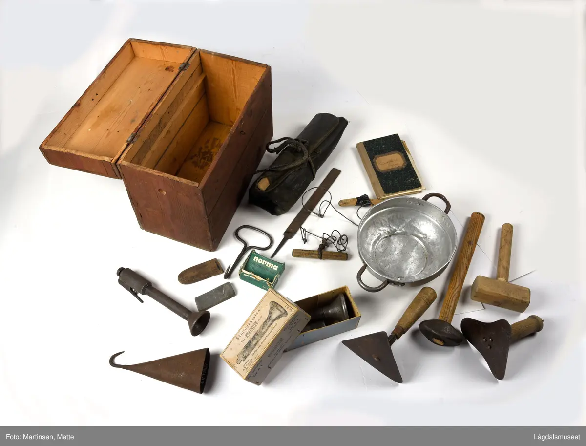 Kiste eller utstyrkiste til diverse redskaper for slakting. Kista er av tre og trolig lagd av materialer fra en margarinkasse. Jamnfør stempel på bunnen. Hengslet lokk med håndtak. Krok foran til låsing. Malt i en rødbrun farge.