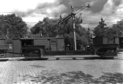 Godsvagnar på järnvägsspår med järnkonstruktion i förgrunden