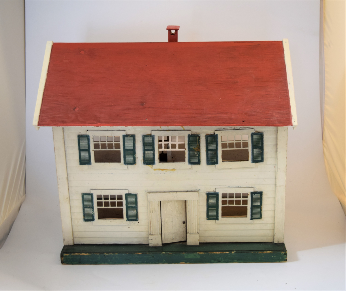 Amerikansk dukkehus tilhørende en jente som var barn av norske arbeidsutvandrere i Brooklyn (1945). 

Det er laget som en kasse hvor den ene langsiden mangler. Huset er delt inn i to etasjer med totalt fire rom, (to stuer, bad og soverom) og tak med pipe som kan løftes av. Opprinnelig hadde det elektriske lamper som lyste. Møbler kom etter hvert, først tremøbler og senere moderne bakelittmøbler. Eier tapeteserte huset selv (med hjelp av en voksen) og brukte tapetrester fra et hus på Long Island. 

Senere ble dukkehuset tatt med til Mandal (1947), hvor det ble benyttet adapter slik at lysene kunne skinne og det vakte stor beundring hos de norske barna.

Huset fikk noen nye reperasjoner i 2003, da det fremdeles var i bruk av første eiers barnebarn.