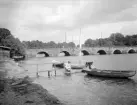 Parti av Motala vid 1900-talets första tid. I bakgrunden den ståtliga Storbron eller även Strömbron över Motala ström. Bron uppfördes i nio spann under åren 1786-87. Sedan 1936 bär den ett överkragat betongdäck som varit nödvändigt men försvagat brons tidigare mer smäckra uttryck.