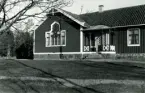 Njutemåla skola. Ett stort detaljrikt fönster i fasaden bredvid verandan.