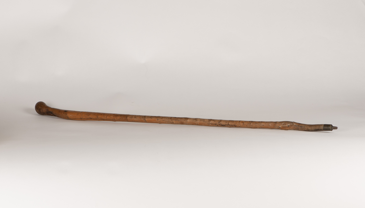 Spaserstokk laget av et trestykke/en grein. I den ene enden kuleformet, denne fungerer som håndtak. I den andre enden påsatt en pigg av jern.