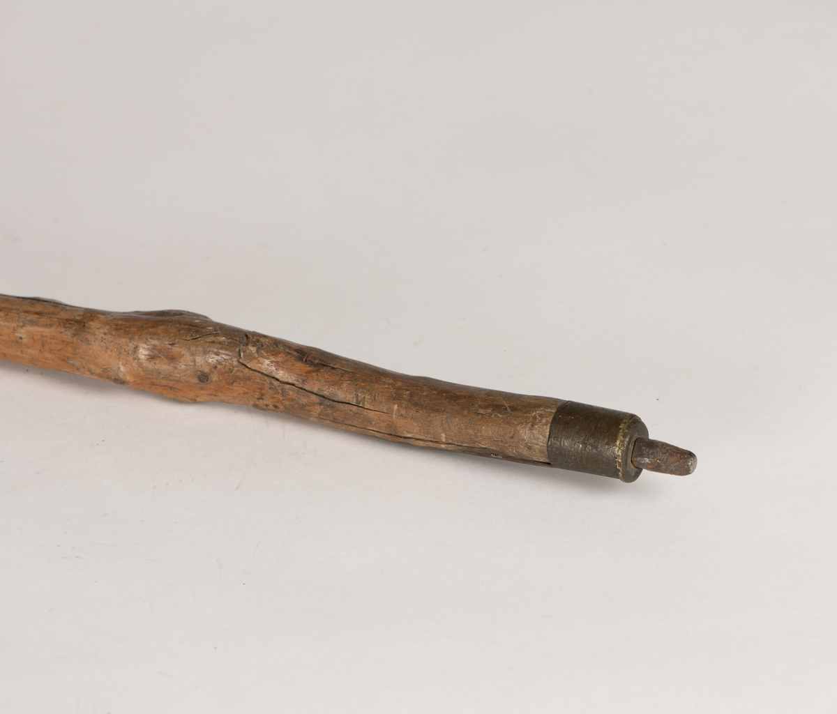 Spaserstokk laget av et trestykke/en grein. I den ene enden kuleformet, denne fungerer som håndtak. I den andre enden påsatt en pigg av jern.