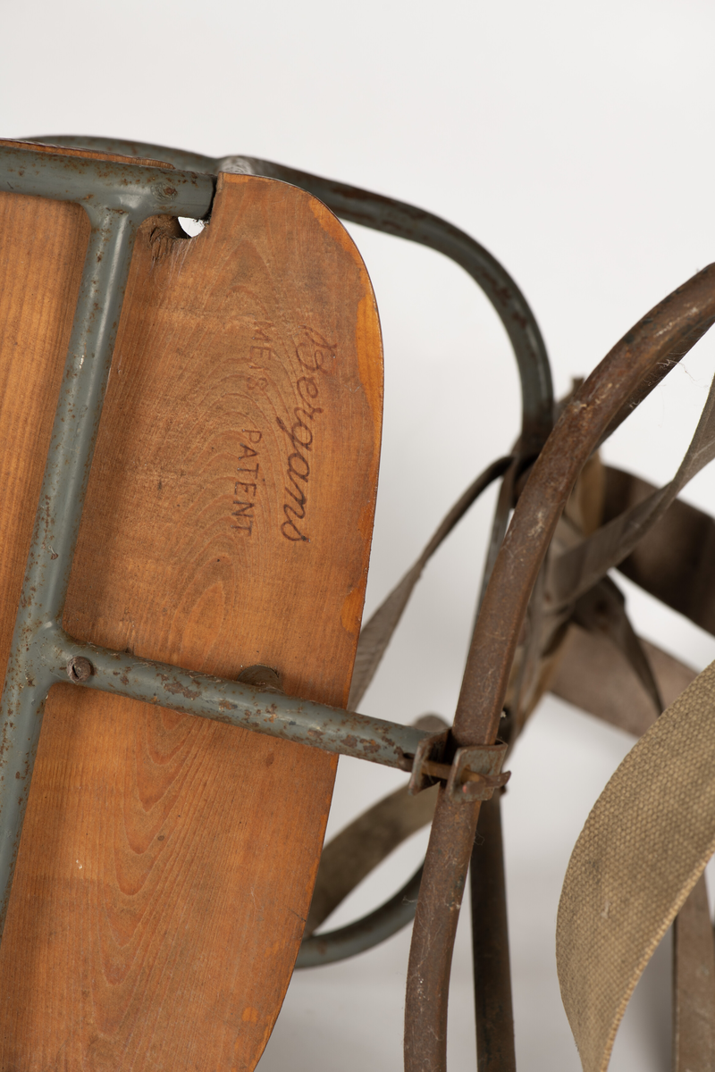 Bæremeis for å bære barn på ryggen. Bergans meispatent med stativ for rygg og sete laget av jernrør. Ryggreimer i lær, reim for korsrygg i grov lerret. Sete i tre.