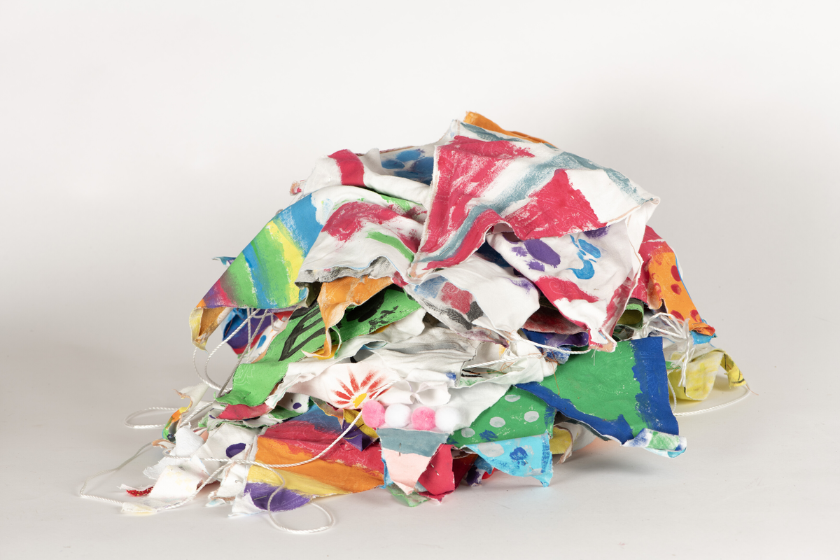 Doble stoff-trekanter dekorert av skoleelever i Arendal, festet til en lang snor. 32 vimpler. Alle har ulik dekor/motiv.