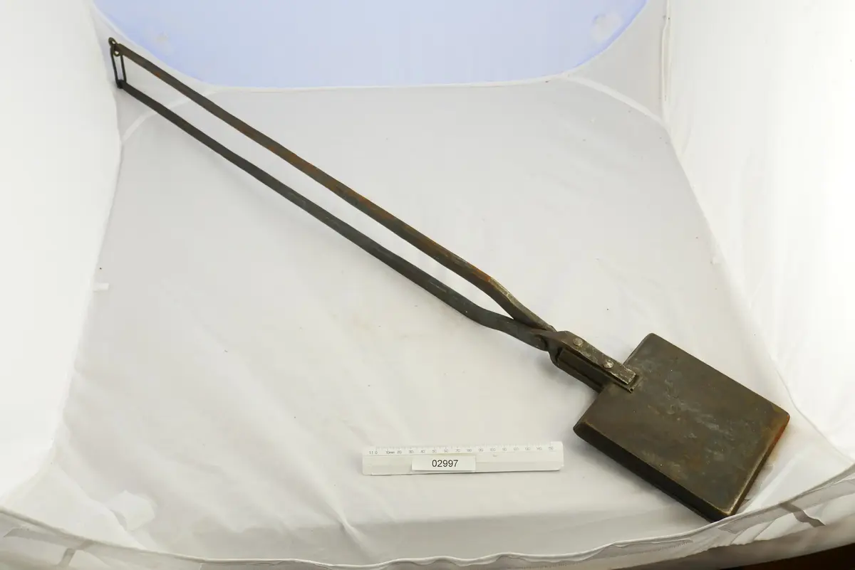 Rånjärn (fyrkantigt) av gjutjärn med långa skänklar,vackert mönstrat inuti järnet med krusiduller.
Troligen avsedd för rånbakning över öppen eld.
Bild 2 visar järnet i öppet läge.