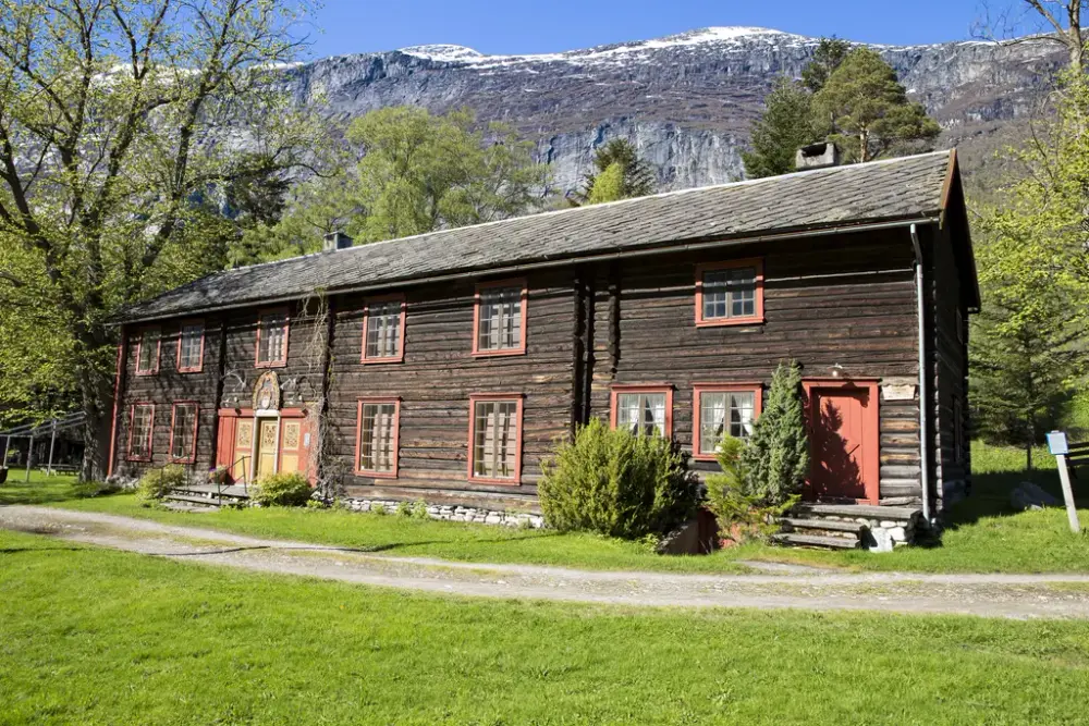 Tømemrbygning med fjell i bakgrunnen