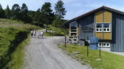 Bilde av familie ved inngangen til Gamle Kvernes bygdemuseum