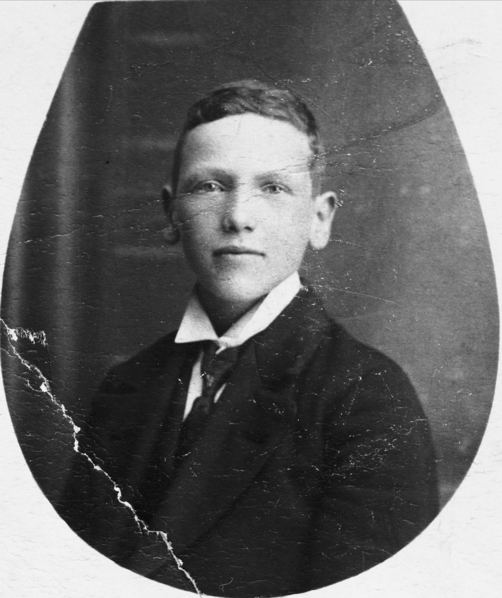 Studioportrett av en ung mann i dress og slips.