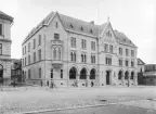 Fotoåret 1903 kunde Riksbanken ta sitt kontor i Linköping i besittning. Bakgrund och behov var statens monopolisering av landets sedelutgivning som kom att gälla från 1897. Bankhuset var ritat av den från Stockholm verksamme Fredrik Olaus Lindström och förändrade stort karaktären av gatuavsnittet. Tomten hade tidigare utgjort platsen för stadens teater, Assemblé- och spektakelhuset, ett träslott med ålderdomligt uttryck.