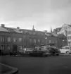 Hospitalstorget i Linköping. Torget har in i modern tid upplåtits för bilparkering men den var redan vid mitten av 1950-talet reglerad. Mot torgets västra sida har Portlösa bildat fond sedan byggnaden fick sin karaktär vid mitten av 1850-talet. Sitt folkliga namn fick huset eftersom den långa fasaden mot torget länge saknade dörr.