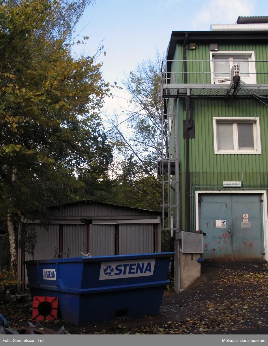 Ett plåtskjul och en grönmålad byggnad vid Soabs industrianläggning i Mölndals Kvarnby, år 2007. Framför byggnaderna står en blå container. Anläggningen användes vid fototillfället av Hexion Speciality Chemicals Sweden AB.