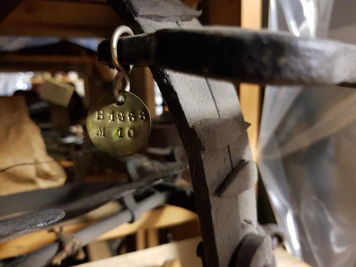Bjørnesaks. Fra protokollen: Bøylesaks med jernplate for åte m. felleinnstilling. Bøylane har 2 cm. lange påklinka jernpiggar. Sterk 2" brei spennfjær som slår bøylane ihop.