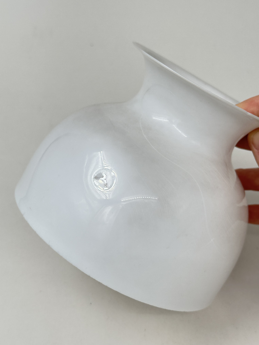 Kupa till rovoljelampa. Av vitt, slätt opalglas med midja och en liten produktionsdefekt i form av två inbuktningar mitt på kupan. 