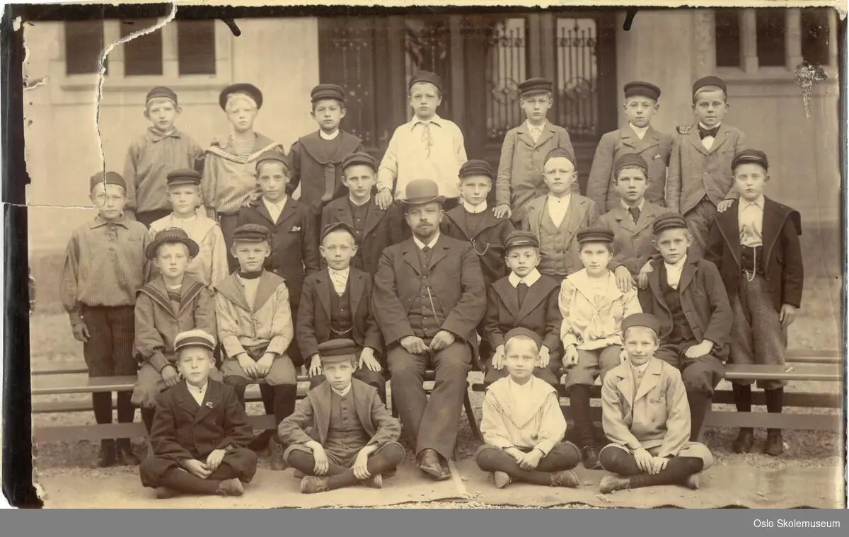 Klassebilde av gutteklasse med lærer på Vestheim skole i 1898 oppstilt foran skolen.